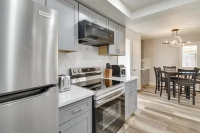 a kitchen with white cabinets and a stainless steel refrigerator at 2 Mi to UC Merced Modern Home with Private Yard in Merced