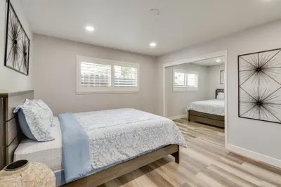 a bedroom with two beds and a mirror at 2 Mi to UC Merced Modern Home with Private Yard in Merced
