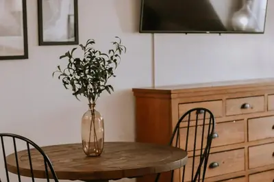 a table with a vase with a plant in it at Peytons Luxury Suite at The Four Daughters Inn in Oakhurst