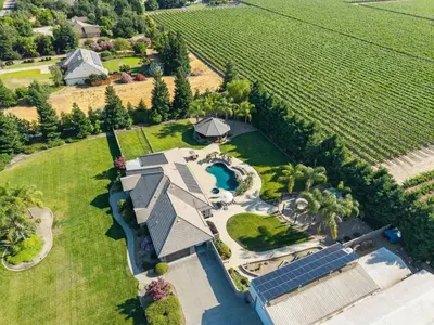 an aerial view of a large house with a swimming pool at Oasis on the vine - Custom Luxury Resort Amenities in Lodi