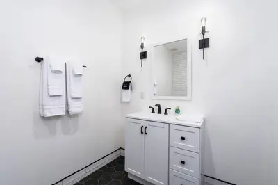 a white bathroom with a sink and a mirror at Kassidy Suite at The Four Daughters Inn in Oakhurst