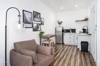 a living room with a couch and a kitchen at Kassidy Suite at The Four Daughters Inn in Oakhurst