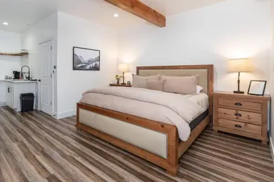 a bedroom with a large bed and a table and a desk at Kassidy Suite at The Four Daughters Inn in Oakhurst