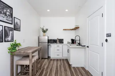 a kitchen with a table and a refrigerator at Kassidy Suite at The Four Daughters Inn in Oakhurst