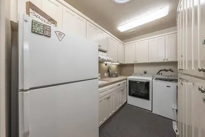 a kitchen with white cabinets and a white refrigerator at Multi-Family Villa-private spa waterfall in Shaver Lake