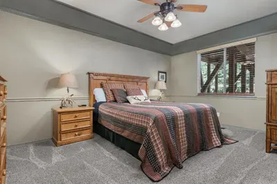 a bedroom with a bed and a ceiling fan at Lazy Bear Lodge Rustic Luxe Villa with spa & gameroom in Shaver Lake