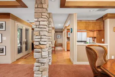 a living room with a stone pillar and a table and chairs at Single level Family cabin-Fenced in yard for pets & kids in Shaver Lake