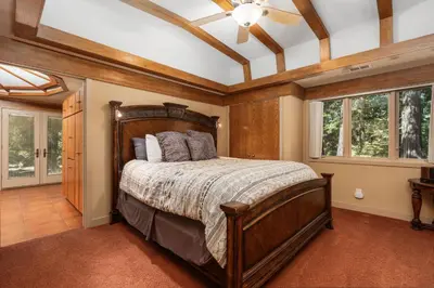 a bedroom with a wooden bed in a room with windows at Single level Family cabin-Fenced in yard for pets & kids in Shaver Lake