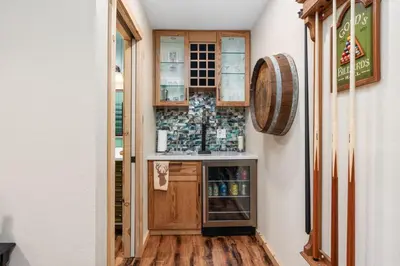 a hallway with a bar in a room with wood floors at Cedar Horn- Serene Family Shaver Retreat in Shaver Lake
