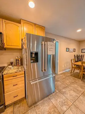 a kitchen with a stainless steel refrigerator and wooden cabinets at Bear Bottoms Family Cabin-Huge GAME ROOM in Shaver Lake