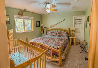 a bedroom with a bed and a ceiling fan at Bear Bottoms Family Cabin-Huge GAME ROOM in Shaver Lake