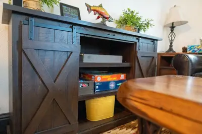 a wooden cabinet with a door in a living room at Kamp Kokanee-Updated Condo Near Spa Sauna in Shaver Lake