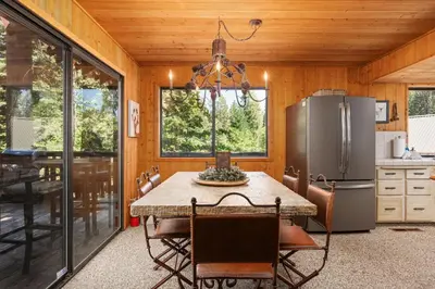 a kitchen with a table and a refrigerator at Wyldwood-Family Friendly-LOFT & BAR in Shaver Lake
