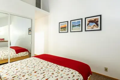a white bedroom with a bed and a mirror at Snowcreek V 870 in Mammoth Lakes
