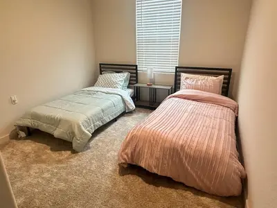 a bedroom with two beds and a window at A modern retreat and Gateway to Yosemite in Merced