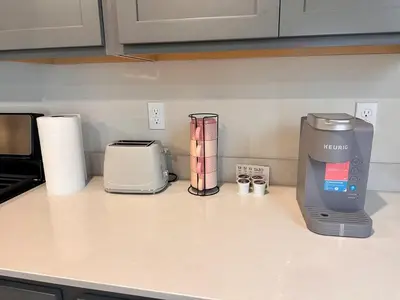 a kitchen counter with a coffee maker and other appliances at A modern retreat and Gateway to Yosemite in Merced