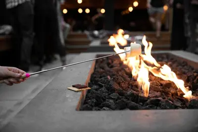 a person is lighting a fire in a grill at The Coachman Hotel in South Lake Tahoe