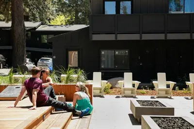 a group of people sitting on a wooden bench at The Coachman Hotel in South Lake Tahoe