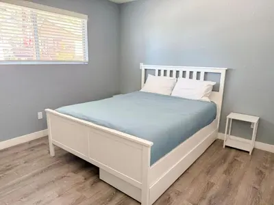 a bedroom with a white bed with blue sheets and a window at Charming Lake Tahoe Getaway 30 Plus Days Bookings Only Accepted in Zephyr Cove