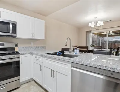 a kitchen with white cabinets and a sink at Casa Cortez C in Visalia