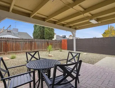 a patio with a table and chairs and a fence at Casa Cortez C in Visalia