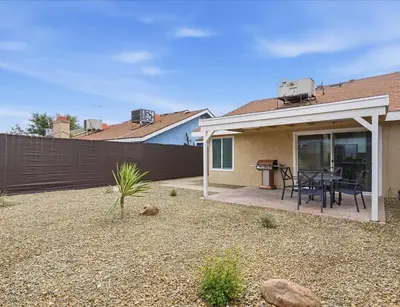 a house with a patio with a table and a fence at Casa Cortez C in Visalia
