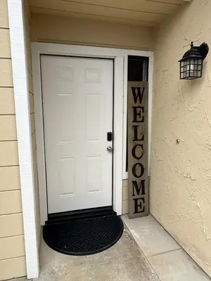 a white door with a black mat in front of a house at Casa Cortez C in Visalia