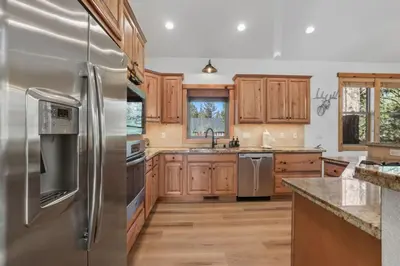 a kitchen with wooden cabinets and stainless steel appliances at Evergreen Getaway Pet Friendly in SLT w Hot Tub in South Lake Tahoe