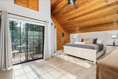 a bedroom with a bed and a sliding glass door at Apple Blossom Lodge-Family Friendly Cabin in Shaver Lake