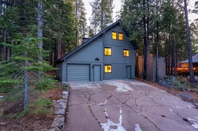 a house with a garage in the woods at Kokanee Hideaway-Family Friendly 5BR Epic Game Room in Shaver Lake