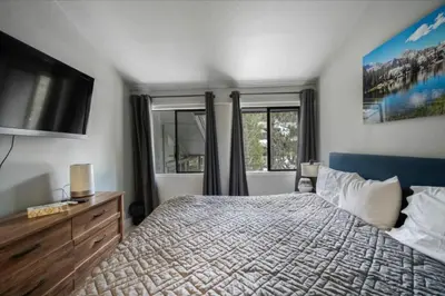a bedroom with a bed and a flat screen tv at Guest Favorite Spacious Remodeled 2 Bdrm 2 Ba Mountain Views in Mammoth Lakes
