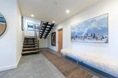 a hallway with a staircase and a painting on the wall at Aerial Grace Lakeside – 4BR Luxury w/ Private Beach, Pier, Sauna in Tahoma