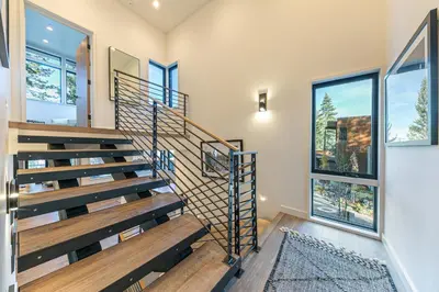 a staircase in a house with two windows at Aerial Grace Lakeside – 4BR Luxury w/ Private Beach, Pier, Sauna in Tahoma