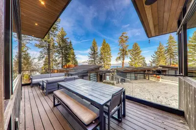 a deck with a wooden table and benches on it at Aerial Grace Lakeside – 4BR Luxury w/ Private Beach, Pier, Sauna in Tahoma