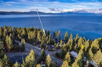 an aerial view of a lake with trees and a pole at Aerial Grace Lakeside – 4BR Luxury w/ Private Beach, Pier, Sauna in Tahoma