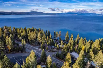 an aerial view of a lake with trees and water at Aerial Grace Lakeside – 4BR Luxury w/ Private Beach, Pier, Sauna in Tahoma