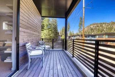 a balcony with two chairs on a wooden deck at Starfall Run at Palisades by Tahoe Getaways - Luxury 3BR w Ski Shuttle, A/C & Bonus Room! in Alpine Meadows