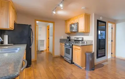 a kitchen with wooden cabinets and a black refrigerator at The Heavenly Foothills For 4 in South Lake Tahoe