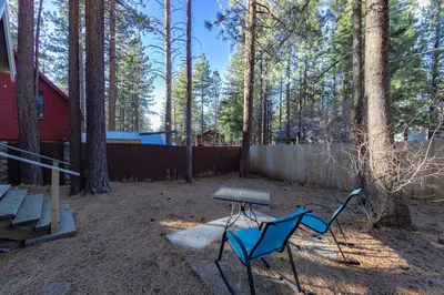 two chairs and a table in a yard with a fence at The Heavenly Foothills For 4 in South Lake Tahoe