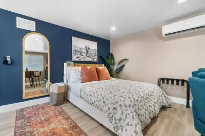 a bedroom with a bed and a blue wall at Boho Chic Dt Visalia W Modern Art Flair in Visalia