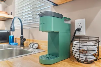 a green coffee maker on a counter next to a sink at Boho Chic Dt Visalia W Modern Art Flair in Visalia
