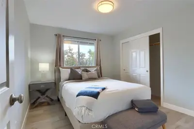a bedroom with a large white bed with a window at Amazing Views Hot Tub-Games-Fire pit 6BR Sleeps 20 in Oakhurst