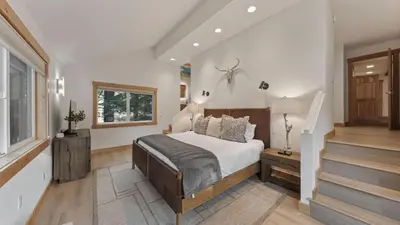 a bedroom with a bed and a staircase with a window at Near Ski Resorts Downtown Truckee Donner Lake Basque Lodge by AvantStay in Truckee