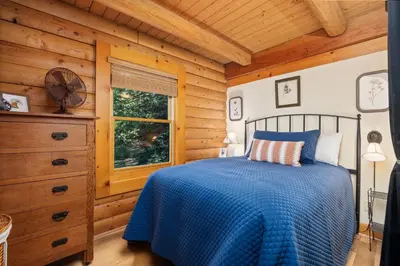 a bedroom with a blue bed and a window at Happy Trails-Family Style Log Home Winter Escape in Shaver Lake