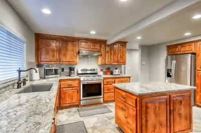 a kitchen with wooden cabinets and stainless steel appliances at Villager in the Heart of Shaver Family Friendly in Shaver Lake