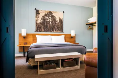 a bedroom with a bed and a painting on the wall at Rush Creek Lodge at Yosemite in Groveland