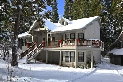a large white house with a deck in the snow at Silverpine Chalet with Gym Family Friendly in Shaver Lake