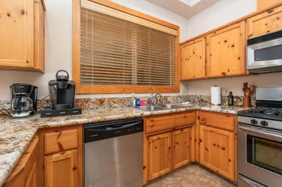 a kitchen with wooden cabinets and stainless steel appliances at Sierra Pines- Family friendly Game Room & Fire Pit in Shaver Lake