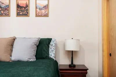 a bedroom with a green bed with a lamp on a table at Sierra Pines- Family friendly Game Room & Fire Pit in Shaver Lake