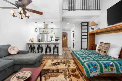a living room with a couch and a kitchen at Wilderness Hideaway-Across from the pool & spa in Shaver Lake